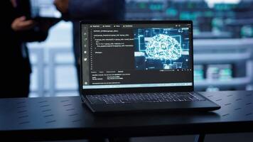 Laptop in data center establishment with artificial intelligence computing simulating human brain. Close up shot of notebook displaying AI machine learning algorithms, camera A video