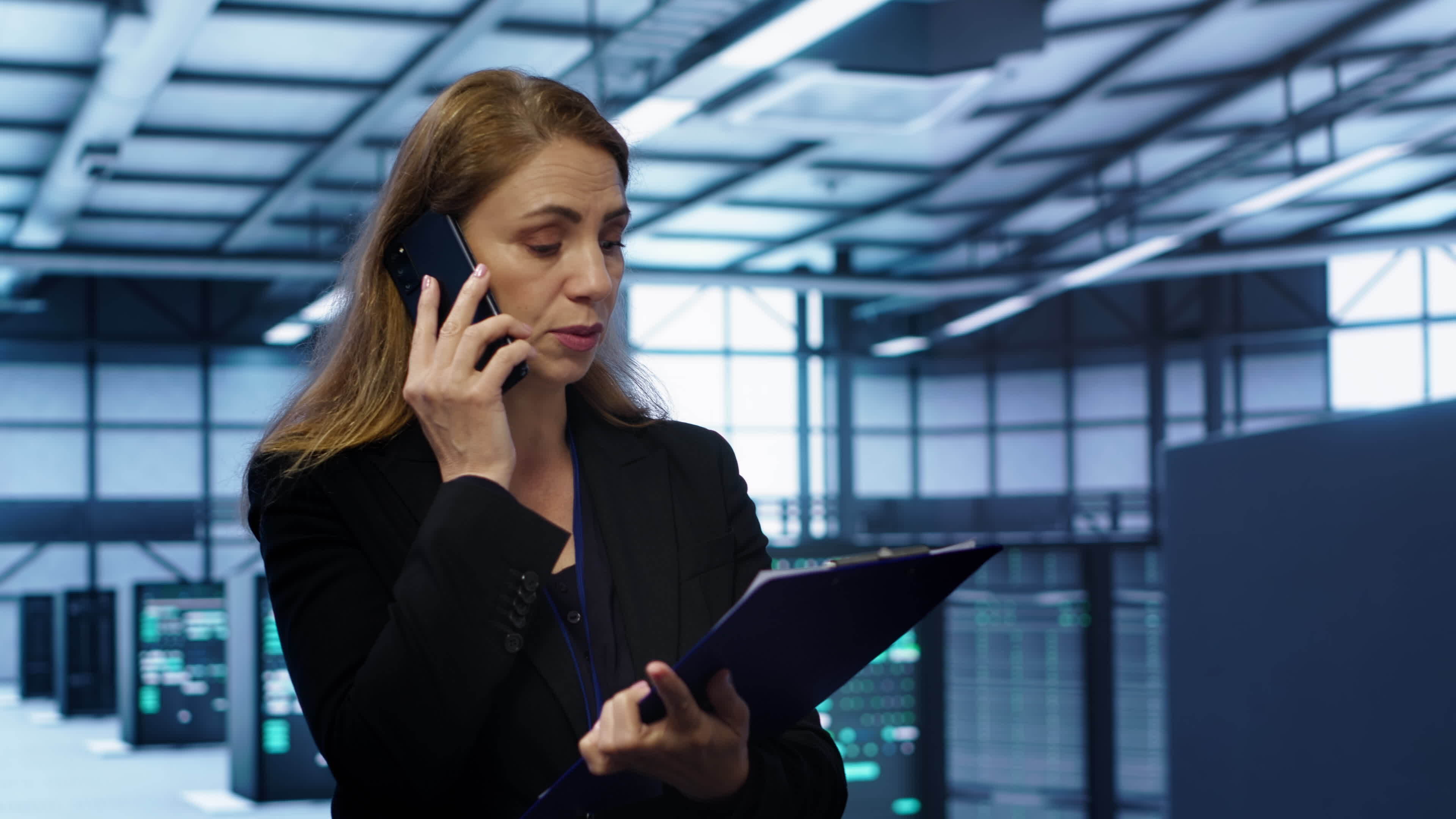 It specialist looking over data center maintenance checklist talking