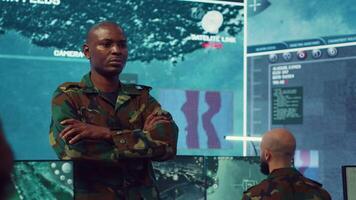 Portrait of confident military general wearing camo uniform in mission control center, overseeing operations regarding the national safety and protocol. Federal army base command post. Camera A. video