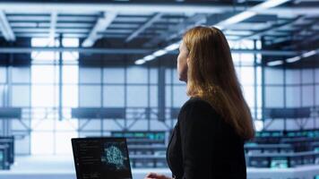 Computer scientist in data center using artificial intelligence computing simulating human brain. IT professional working on notebook with AI machine learning algorithms, camera A video