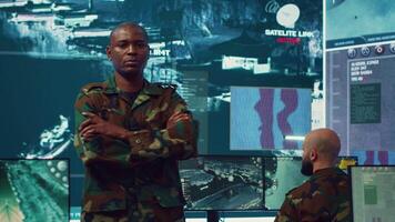 Portrait of national guard commander dressed in military camouflage uniform, team leader overseeing operations in control center. Army officer works on missions at federal agency base. Camera A. video