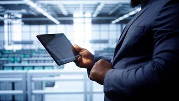 Engineer in high tech facility using tablet to patch network issues leading to slow data transfer rates. Close up of worker fixing errors affecting servers performance and connectivity, camera B video