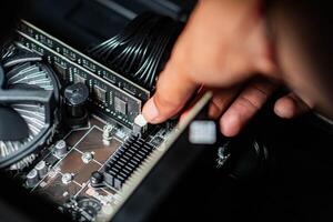 Person adjusting component on computer motherboard photo