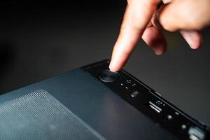 Finger pressing power button on desktop computer case photo
