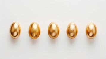 Easter golden decorated eggs stand in a row on white background. Minimal easter concept. Happy Easter card with copy space for text. Top view, flatlay photo