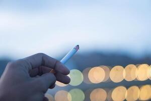 A man with a cigarette enjoys smoking photo