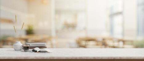 A table features books, a coffee cup, a ceramic vase, and empty space in a contemporary cafe. photo