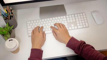 Top view image of an office man is working at his desk, typing on computer keyboard. photo