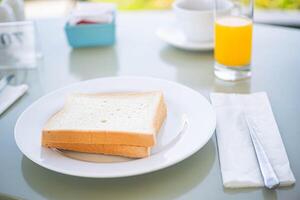 White bread slices with orange juice on breakfast table photo