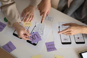 A cropped shot of a group of UX and UI graphic designers working in the meeting. photo