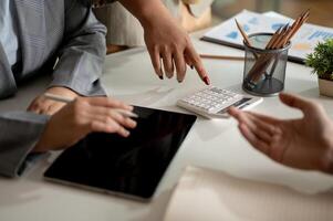 Group of businesspeople working together in the meeting, showing the number on a calculator. photo