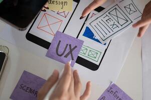 A meeting table with a graphic designer team and various prototype for a new mobile application. photo