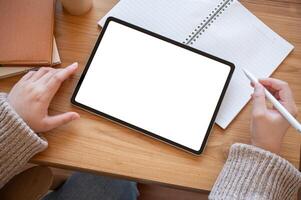 Top view image of a woman using a digital tablet at her desk. people and technology concepts photo