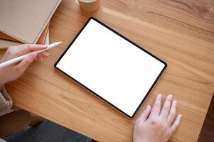 Top view image of a woman using a digital tablet at her desk. people and technology concepts photo