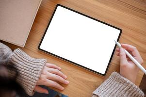 Top view image of a woman using a digital tablet at her desk. people and technology concepts photo