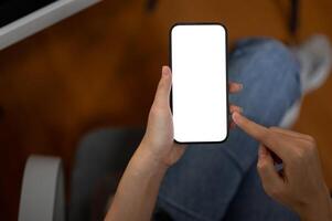 Top view image of a woman using her smartphone in the office. A white-screen smartphone mockup. photo