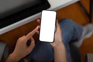 Top view image of a woman using her smartphone in the office. A white-screen smartphone mockup. photo