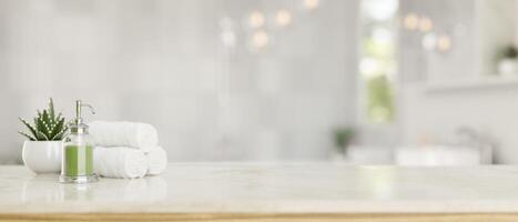 A shower gel bottle, bath towels, and an empty space on a tabletop in a luxury bright bathroom. photo