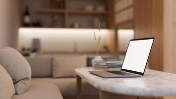 Side view image of a white-screen laptop computer on a coffee table in a modern and cosy living room photo