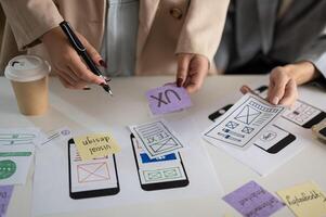 A cropped shot of a group of UX and UI graphic designers working in the meeting. photo
