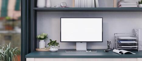 Front view of a white-screen computer mockup and office supplies on a desk in a modern office room. photo