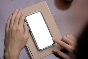 Top view image of a man using his smartphone a table. a white-screen smartphone mockup. photo