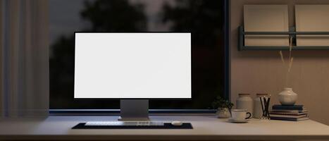 Front view of a white-screen computer mockup on a table in a modern home office at night. photo