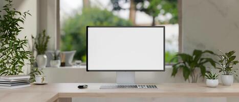 A computer with a white-screen mockup on a wooden table in a modern, minimalist living room. photo