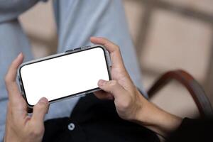 Close-up image of a man using his phone, playing a mobile game or watching a online outdoors. photo