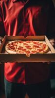 Hands holding a pizza box. Pizza is ready for delivery. . photo