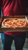Hands holding a pizza box. Pizza is ready for delivery. . photo