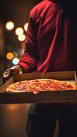 Hands holding a pizza box. Pizza is ready for delivery. . photo