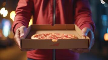 Hands holding a pizza box. Pizza is ready for delivery. . photo
