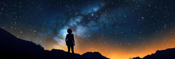 Silhouette of a girl looks at the starry sky. . photo