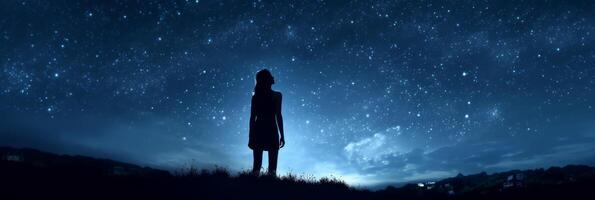 Silhouette of a girl looks at the starry sky. . photo