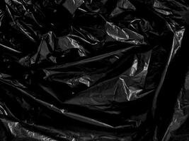 Transparent plastic wrap on the black background. Clean blank texture overlay effect template. Isolated wrinkle surface branding mock-up. photo