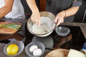 Making a pie in your home kitchen from several types of cheeses, mozzarella, tsfati and others photo