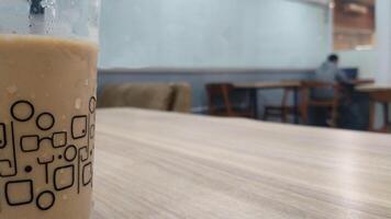 Close up cold espresso coffee on the table, selective focus with one man behind. Blurred background. Copy space for text ad photo