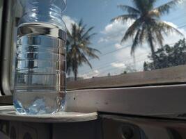 Close up view of mineral water bottle standing near train window. Stay fresh during the trip. photo