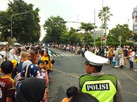 Surakarta City, Central Java, Indonesia, May 15, 2024. Crowd people watching a parade at Slamet Riyadi Street. photo