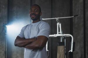 Fitness workout in gym. Portrait of African American man standing in gym with motivation health energy ready for training. Athletic coach personal trainer fitness club owner. Healthy lifestyle photo