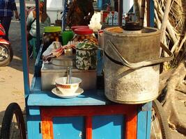 cart selling the traditional Javanese dessert drink wedang ronde. a delicious drink consisting of sticky rice flour filled with peanuts, palm fruit, chopped peanuts and served with ginger syrup. photo