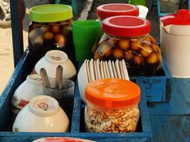 cart selling the traditional Javanese dessert drink wedang ronde. a delicious drink consisting of sticky rice flour filled with peanuts, palm fruit, chopped peanuts and served with ginger syrup. photo