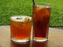 Cold brew fresh iced tea with lemon on wooden table. Refreshing drink on a hot summer day. Cafe image concept design background photo