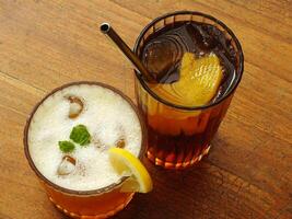 Cold brew fresh iced tea with lemon on wooden table. Refreshing drink on a hot summer day. Cafe image concept design background photo