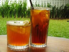 Cold brew fresh iced tea with lemon on wooden table. Refreshing drink on a hot summer day. Cafe image concept design background photo