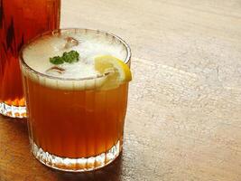 Cold brew fresh iced tea with lemon on wooden table. Refreshing drink on a hot summer day. Cafe image concept design background photo