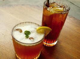 Cold brew fresh iced tea with lemon on wooden table. Refreshing drink on a hot summer day. Cafe image concept design background photo