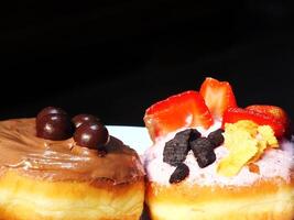 Sweet cake with various topping and sugar cream. Appetizer isolated on black background. Food and beverage image for coffee shop and restaurant business photo