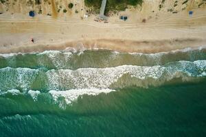 Sand beach with sea waves, top view photo
